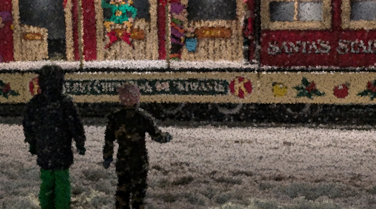 Two children dressed in outdoor winter clothing viewing a parade float at a Santa Clause parade in Canada